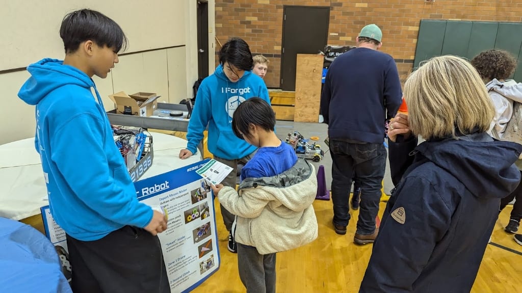 I.F. Robotics members demonstrating a robot to students at an educational workshop